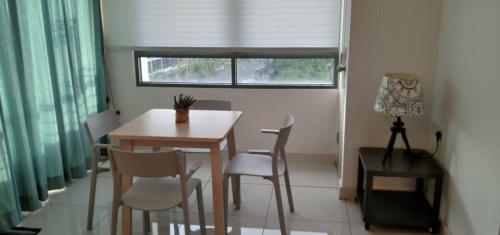 a dining room with a table and chairs and a window at PINTARMAN SUITES @ MIRI TIMES SQUARE in Miri