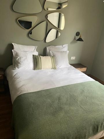 a bedroom with a bed with white sheets and pillows at Le Grand Albert 1er in Maisons-Alfort