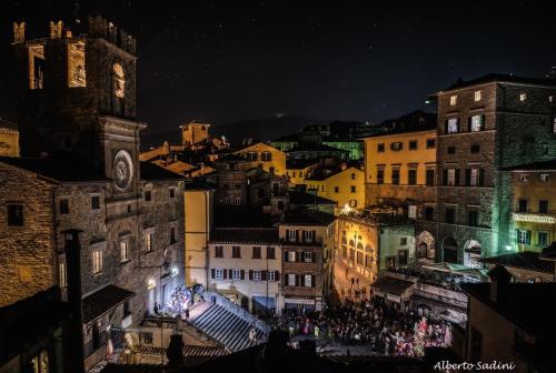 a crowd of people walking around a city at night at Hotel San Michele in Cortona
