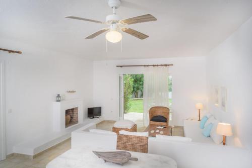 a living room with white furniture and a ceiling fan at Luxury Villa Skiathos Two-Bedroom Suite Dyo Vromolimnos in Skiathos Town
