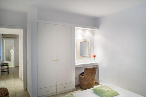 un armadio bianco in soggiorno con tavolo di Luxury Villa Skiathos Two-Bedroom Suite Dyo Vromolimnos a Città di Skiathos