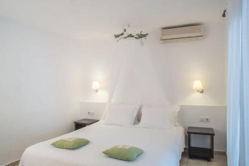 una camera da letto con un letto bianco con due cuscini sopra di Luxury Villa Skiathos Two-Bedroom Suite Dyo Vromolimnos a Città di Skiathos