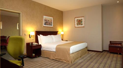 a hotel room with a bed and a chair at Holiday Inn Olaya by IHG in Riyadh