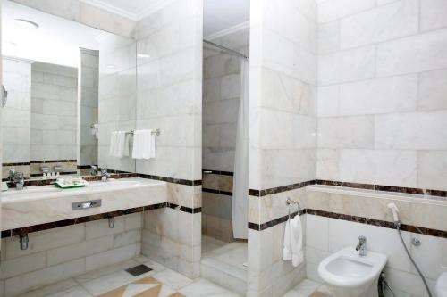 a bathroom with a sink and a toilet and a mirror at Holiday Inn Olaya by IHG in Riyadh