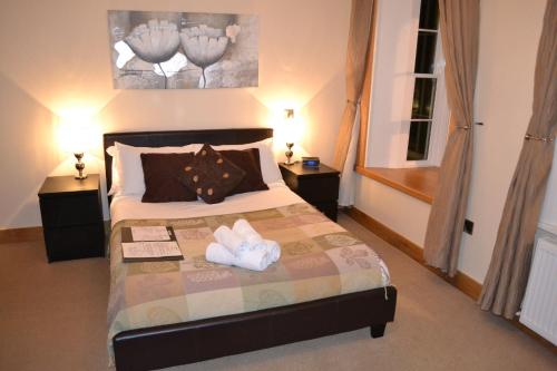 a bedroom with a bed with two towels on it at Bridge View Guest House in Ironbridge