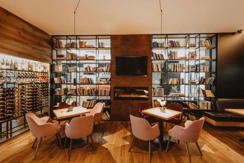 a restaurant with tables and chairs and bookshelves at Hotel Turiec in Martin