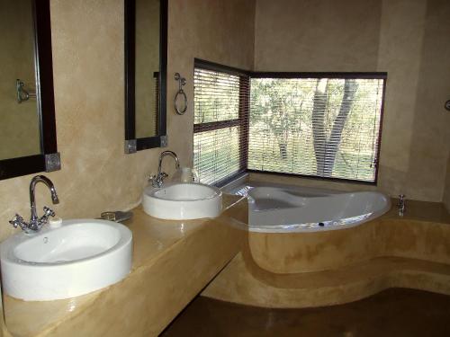 a bathroom with two sinks and a bathtub at Thornhill Safari Lodge in Guernsey Nature Reserve