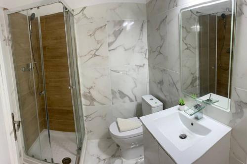 a bathroom with a toilet and a shower and a sink at Barreiro Central Apartment in Barreiro