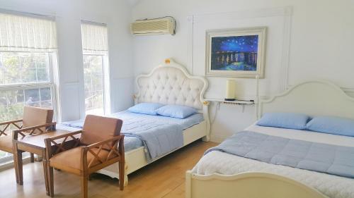 1 Schlafzimmer mit 2 Betten, einem Tisch und Stühlen in der Unterkunft Bella Guesthouse in Tongyeong