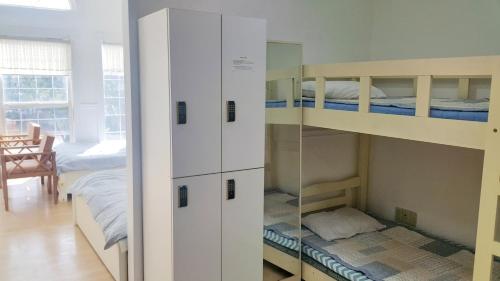 a room with two bunk beds and a mirror at Bella Guesthouse in Tongyeong