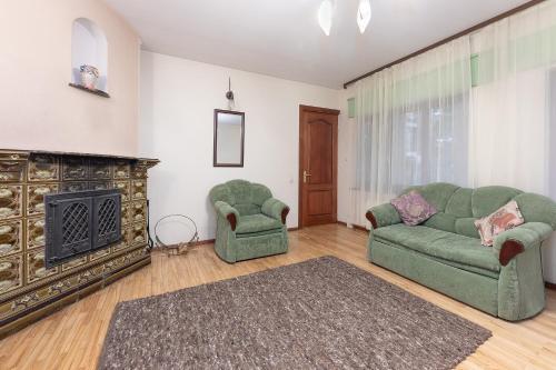 a living room with two green couches and a fireplace at Valensija in Jūrmala