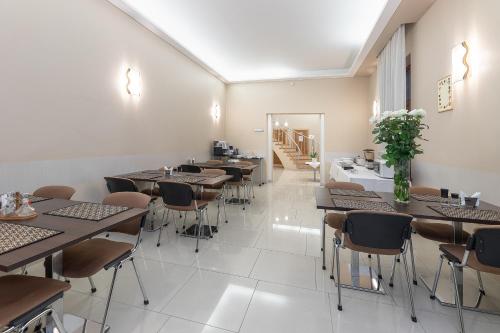 a restaurant with tables and chairs and a staircase at Valensija in Jūrmala
