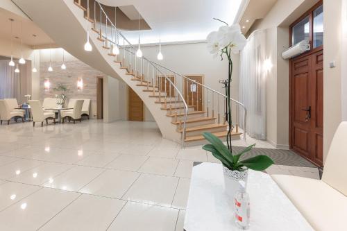a hallway with a staircase and a table with a vase of flowers at Valensija in Jūrmala