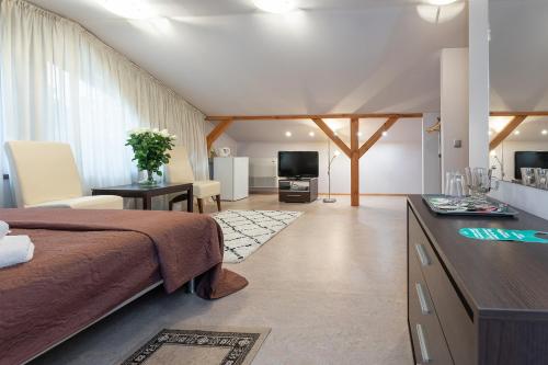 a bedroom with a bed and a desk and a television at Valensija in Jūrmala