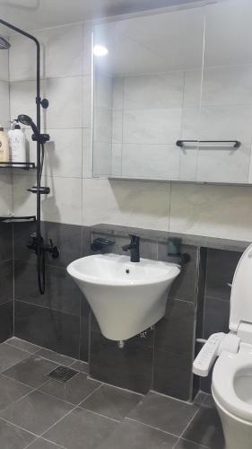 a bathroom with a sink and a toilet at Bella Guesthouse in Tongyeong
