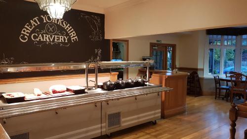 a restaurant with a counter with food on it at The George Carvery & Hotel in Ripon
