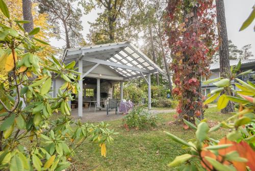 a pavilion in the backyard of a house with trees at Valensija in Jūrmala