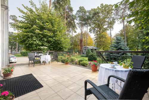 a patio with a table and chairs and trees at Valensija in Jūrmala
