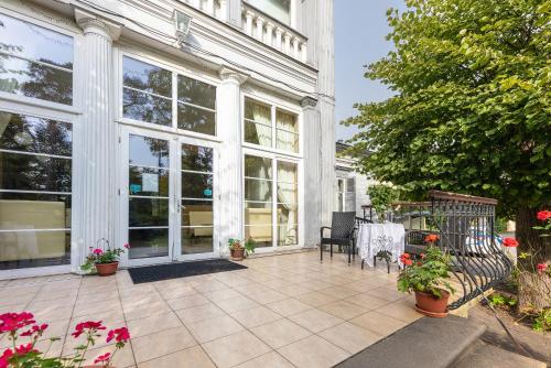 a house with a patio with a table and chairs at Valensija in Jūrmala