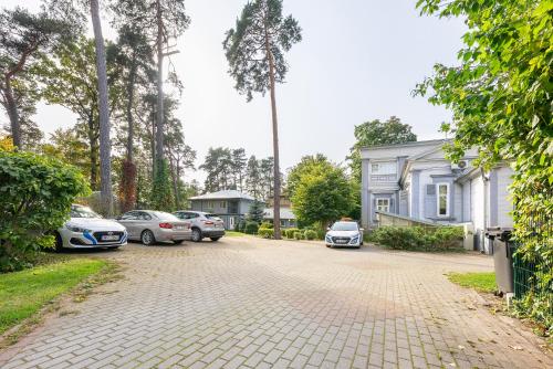 a driveway with cars parked in front of a house at Valensija in Jūrmala