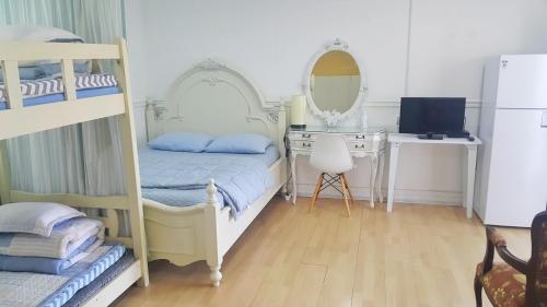 a bedroom with a bunk bed and a desk with a mirror at Bella Guesthouse in Tongyeong