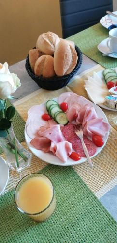 a table with two plates of food and bread at Pension Riverside in Leverkusen Hitdorf am Rhein - Zentral an der A1 und 59 in Leverkusen