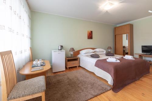 a hotel room with a bed and a table and a television at Valensija in Jūrmala