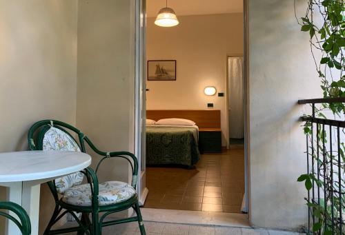a room with a table and chairs and a bed at Hotel Garni Picnic in Riccione