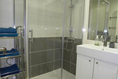 La salle de bains est pourvue d'une douche en verre et d'un lavabo. dans l'établissement Appartement Hyper Centre-Vieux Port-Place aux Huiles, à Marseille