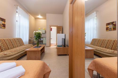 a living room with two couches and a tv at Valensija in Jūrmala