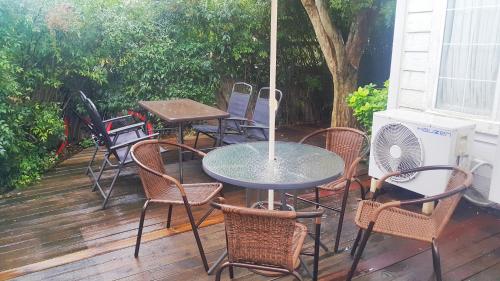 une table et des chaises avec un parasol sur une terrasse dans l'établissement Bella Guesthouse, à Tongyeong
