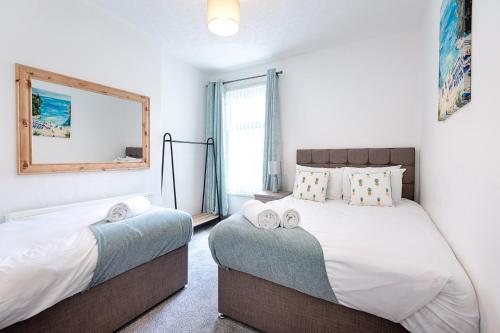 a bedroom with two beds and a mirror at STOP! Stay at The Jersey in Swansea