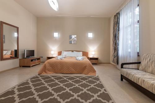 a large bedroom with a bed and a couch at Valensija in Jūrmala