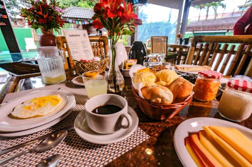 a table with breakfast foods and a cup of coffee at Pousada Pura Vida Maresias in Maresias