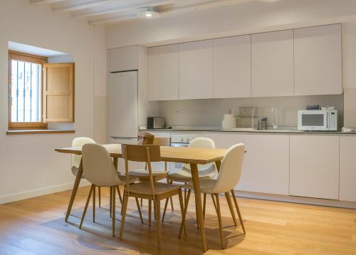 - une cuisine avec une table et des chaises dans la chambre dans l'établissement Apartamento Alcuneza en Elmolinodelasal de Sigüenza, à Sigüenza