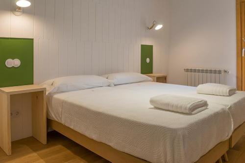 - un grand lit avec 2 oreillers dans l'établissement Apartamento Alcuneza en Elmolinodelasal de Sigüenza, à Sigüenza