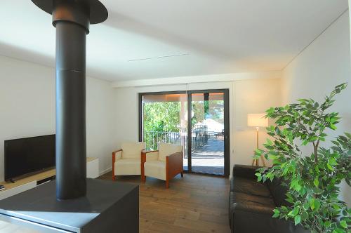 a living room with a stove and a couch and a table at DouroXisto in Peso da Régua