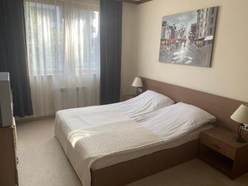ein Schlafzimmer mit einem Bett und einem großen Fenster in der Unterkunft One Bedroom Apartment in Gated Complex in Bansko