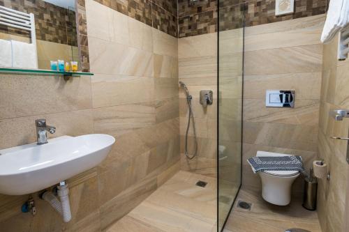 a bathroom with a sink and a shower at KIPOI APARTMENTS in Zakynthos Town