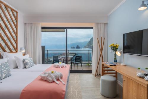 a hotel room with two beds and a balcony at Aqua Natura Bay in Porto Moniz