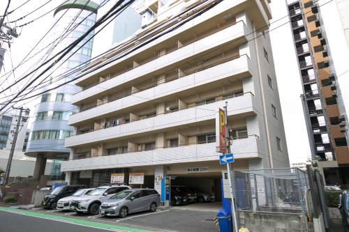um grande edifício com carros estacionados em frente em Gentry Hakata em Fukuoka