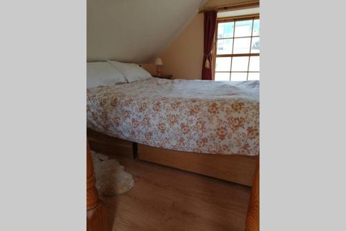 1 dormitorio con cama y ventana en Boghead Cottage: Holiday Cottage in Royal Deeside, en Banchory