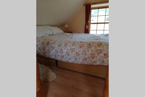 una camera da letto con un letto e una finestra di Boghead Cottage: Holiday Cottage in Royal Deeside a Banchory