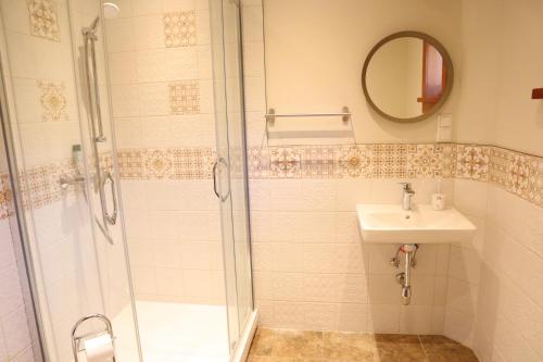 ein Bad mit einer Dusche und einem Waschbecken in der Unterkunft Holiday house with sauna in Riga