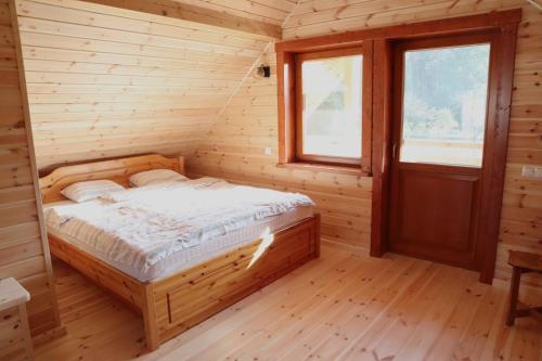 リガにあるHoliday house with saunaの木製の部屋にベッド1台が備わるベッドルーム1室があります。