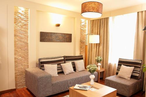 a living room with a couch and two chairs at Reata Apartment Hotel in Nairobi