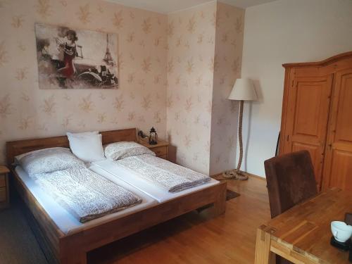a bedroom with a bed and a table and a lamp at Gasthof Alte Post in Rheinhausen