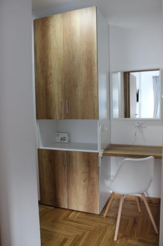 a kitchen with a desk and a white chair at Summit rooms , Parking in garage in Niš