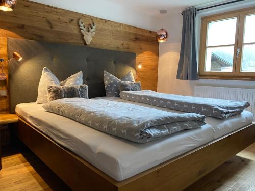 a large bed with pillows on it in a room at Alpin Chalet Kern in Klösterle am Arlberg