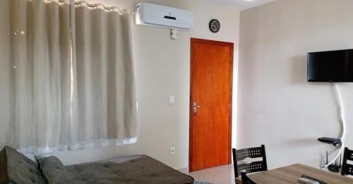 een woonkamer met een bank en een houten deur bij Apartamento Temporada D'Loren dos lagos 4º andar in Capitólio